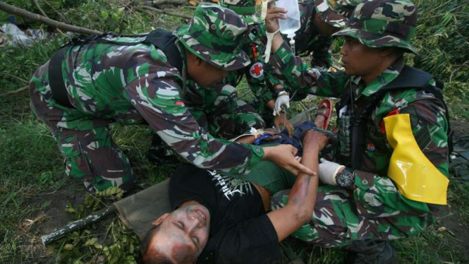 Prajurit dari pleton kesehatan memberikan pertolongan medis kepada korban tanah longsor di pelatihan penanggulangan bencana Kota Kediri, Jawa Timur, Jumat (3/6/2016).