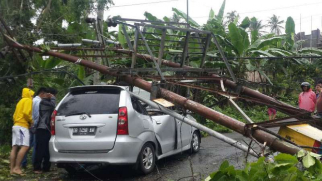 Mobil tertimpa tiang listrik yang roboh akibat angin kencang di Kota Manado, Sulawesi Utara, pada Selasa, 21 Juni 2016.