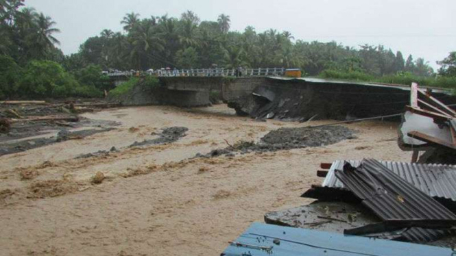 Sebuah jembatan rusak akibat banjir bandang di Kabupaten Kepulauan Sangihe, Sulawesi Utara, Rabu, 22 Juni 2016.