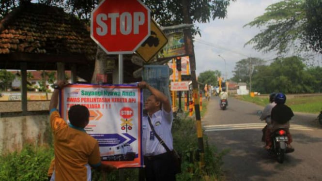 Petugas PT KAI Daerah Operasi VII Madiun memasang tanda peringatan di perlintasan kereta api tak berpalang pintu di 35 titik pada Rabu, 22 Juni 2016.