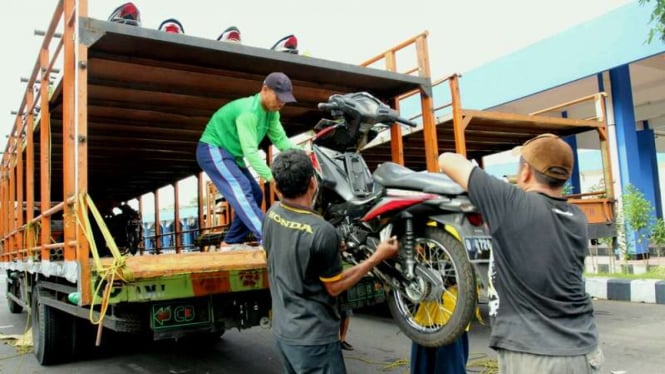 Petugas sedang menurunkan motor milik pemudik yang dikirimkan lewat truk di Solo Surakarta, Jumat (1/7/2016). Ribuan motor ini tiba lebih dahulu dibanding pemiliknya