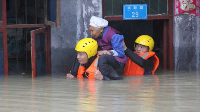 Petugas SAR tengah mengevakuasi lansia yang terjebak banjir di China, Senin, 4 Juli 2016.