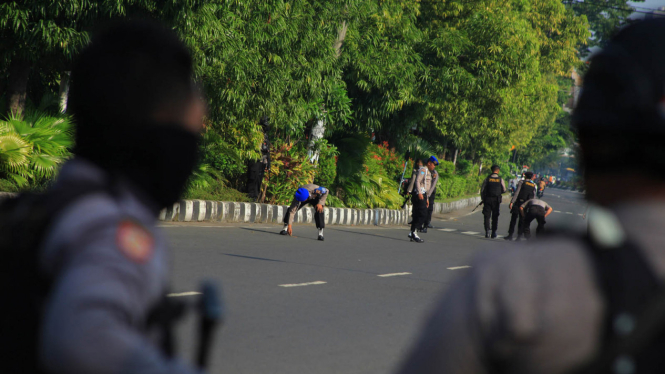 Polisi menyisir jalan untuk mencari serpihan bom saat proses identifikasi terhadap pelaku bom bunuh diri di Mapolresta solo, Jawa Tengah, Selasa (5/7/2016).