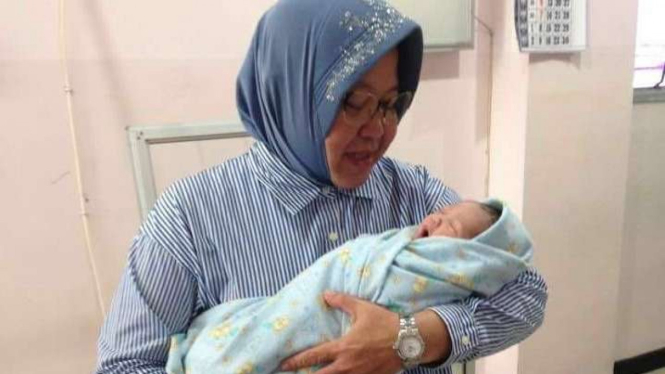 Wali Kota Surabaya, Tri Rismaharini atau Risma, menggendong cucu pertamanya.