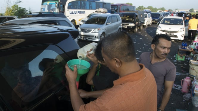 Pemudik mengisi bahan bakar mobil eceran di arah keluar pintu tol Pejagan, di H-2 Lebaran, Jawa Tengah, Senin pagi (4/7/2016). 