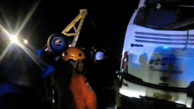 Petugas mengevakuasi bus Kramat Jati yang terguling setelah menabrak truk di Batang, Jawa Tengah, pada Sabtu tengah malam, 16 Juli 2016.