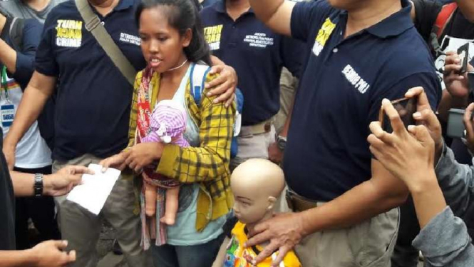 Ade Irma Suryani (gendong boneka) dalam rekonstruksi kaburnya tahanan Salemba