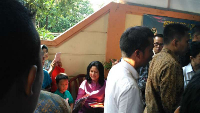Ibu Negara, Iriana Jokowi, membagikan buku saat memantau pemberian vaksin ulang 