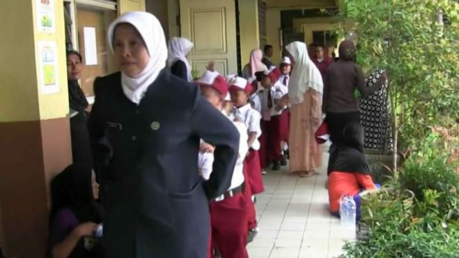 Guru mengajak siswa keliling SDN 05 Pagi Rorotan di hari pertama sekolah, Senin, 18 Juli 2016.