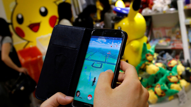 Seorang warga memainkan game ponsel Pokemon Go di Tokyo, Jepang. 