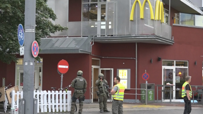 Potongan gambar dari video memperlihatkan pasukan khusus kepolisian berjaga di depan restoran cepat saji pascapenembakan di pusat perbelanjaan Olympia, Munich, Jerman, 22 Juli 2016. 
