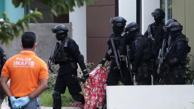  Anggota Tim Densus 88 Antiteror mengamankan sebuah tas yang berisi sebuah senjata laras panjang saat melakukan penggeledahan di salah satu rumah terduga teroris di Batam, Kepulauan Riau, Jumat (5/8).