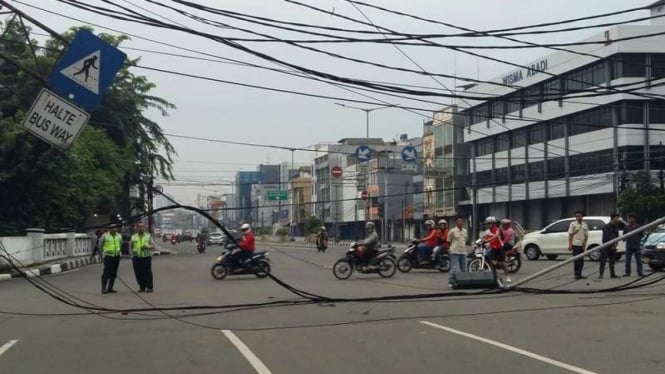 Tiang listrik roboh di ruas Jalan Tarakan kawasan Cideng Jakarta Pusat, Senin pagi, 15 Agustus 2016.
