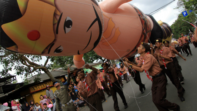 Sejumlah anggota pramuka Kwarcab Trenggalek mengarak balon raksasa berbentuk tokoh pewayangan Pandawa Lima di jalanan Kota Trenggalek, Jawa Timur, Minggu (14/8/2016). 