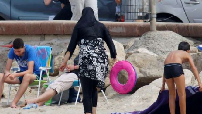 Seorang Muslimah mengenakan burkini di pantai Marseille, Prancis.