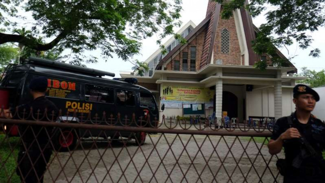 Polisi berjaga di halaman Gereja Katolik Stasi Santo Yosep, Medan.