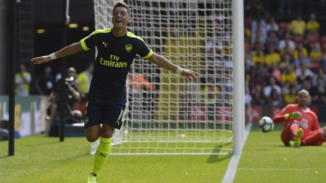 Bintang Arsenal, Mesut Oezil, melakukan selebrasi usai mencetak gol