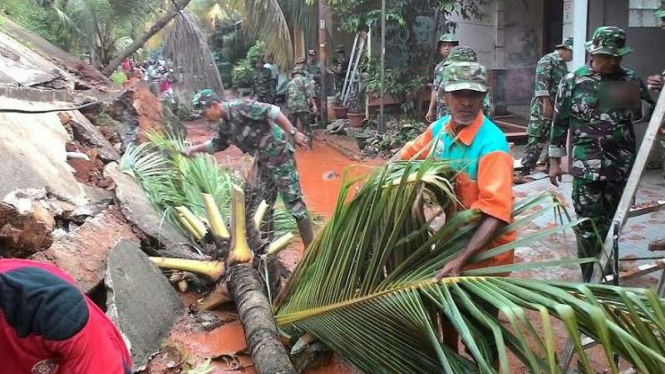 Prajurit TNI dan warga bersihkan material longsor di Depok.