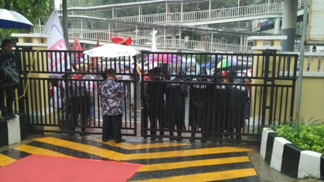Massa pendukung Ahok-Djarot diguyur hujan di depan kantor KPUD DKI.