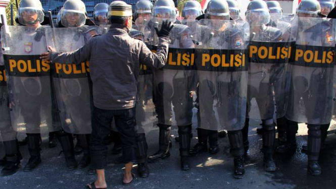 Warga berdialog dengan anggota kepolisian yang melakukan pengamanan saat terjadi bentrok antarwarga di Kawasan Balla Lompoa, Kabupaten Gowa, Sulawesi Selatan, Senin (12/9/2016).