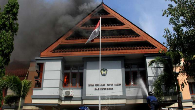 Petugas pemadam kebakaran berusaha memadamkan api saat kebakaran di kantor DPRD Kabupaten Gowa, Sulawesi Selatan, Senin (26/9/2016).