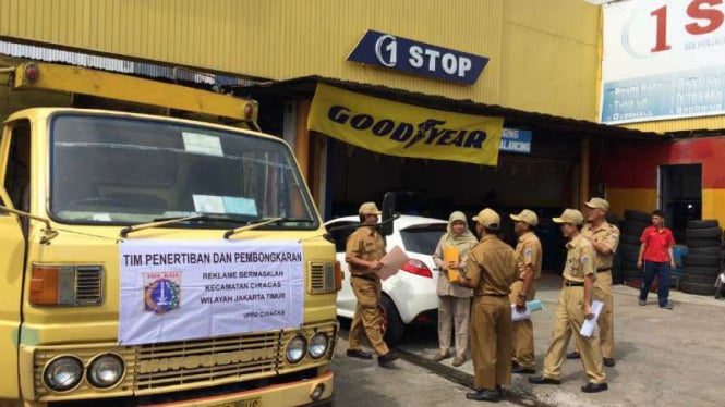 Petugas bersiap menertibkan reklame di Ciracas, Jakarta Timur