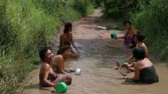 Rombongan nenek di Thailand ini memilih mandi di kubangan sebagai protes.