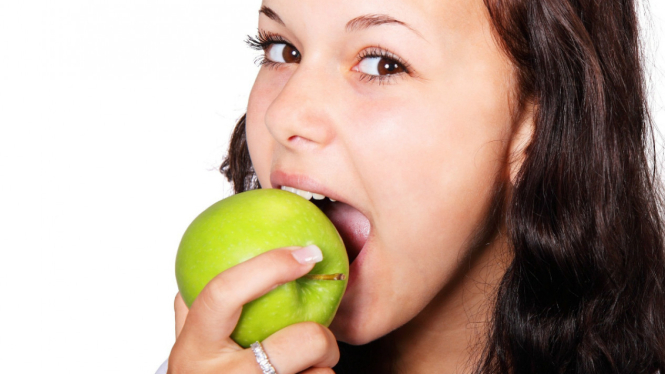 Ilustrasi wanita makan apel.