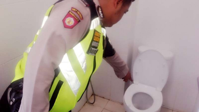 Petugas kepolisian menunjukkan toilet yang menjadi tempat pembuangan bayi di RS Siloam Tangerang Selatan, Sabtu (1/10/2016)
