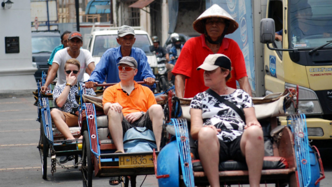 Sejumlah wisatawan asal Belanda dan Australia berkeliling dengan menggunakan becak di kawasan Kota Lama Semarang, Jawa Tengah..