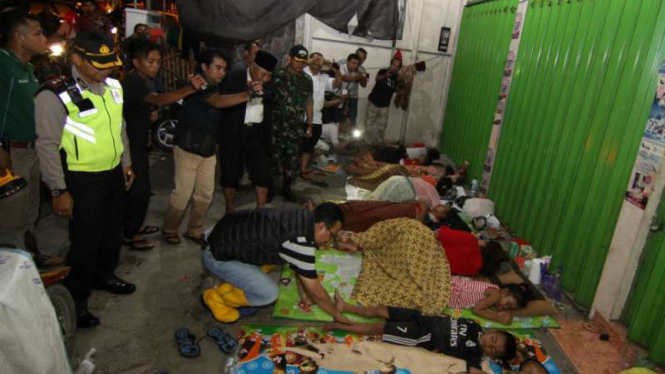 Para warga korban banjir di Sampang, Madura, Jawa Timur, tidur di emperan toko pada Rabu, 12 Oktober 2016.