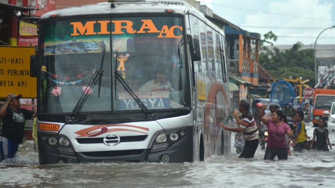 Sebuah bus melaju kencang menerobos banjir di sidoarjo