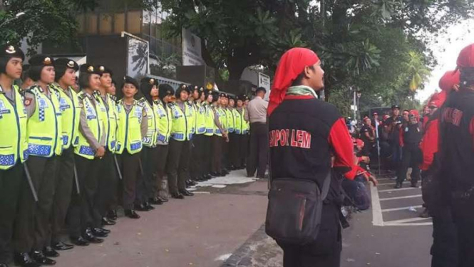 Polisi wanita menjaga jalannya aksi unjuk rasa buruh di Disnakertrans DKI.
