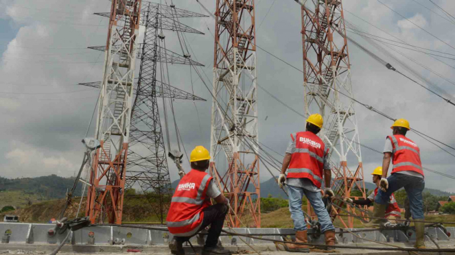 Pekerja memasang kawat baja sebelum pengujian tower transmisi listrik milik PLN. Foto ilustrasi