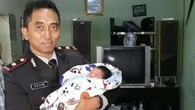 Kapolsek Cimanggis, Kompol Agung menggendong bayi yang dibuang orang tua.