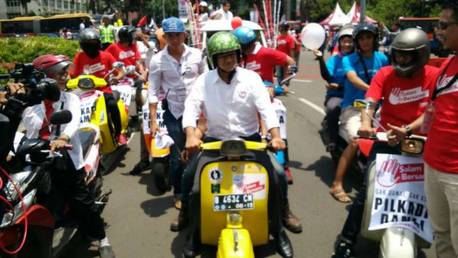 Cagub DKI nomor urut 3 Anies Baswedan naik Vespa saat pawai kampaye damai.