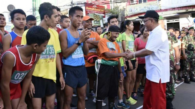 Suryanto disalami panitia saat maraton 10 kilometer di Kota Depok.
