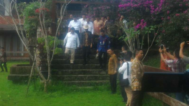 Jokowi mengenakan topi koboi di kediaman Prabowo Subianto.