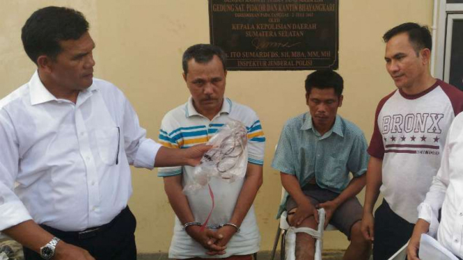 Polisi memperlihatkan dua tersangka perampokan disertai pembunuhan di Markas Polda Sumatera Selatan di Palembang pada Senin, 31 Oktober 2016.