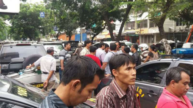 Para sopir taksi online mendampingi rekan mereka lapor ke Polsek Senen
