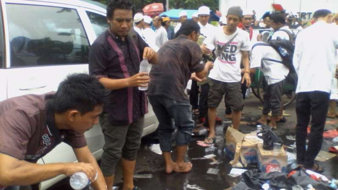 Demonstran menggunakan air mineral untuk berwudhu.