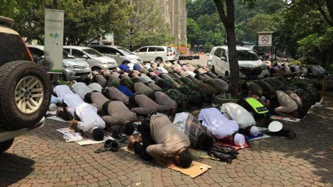 Anggota Kepolisian dan TNI salat Jumat di halaman Gereja Katedral, Jakarta, Jumat, 4 November 2016.