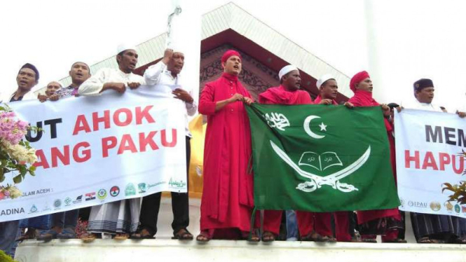 Massa berunjuk rasa menuntut pengusutan kasus peninstaan agama oleh Basuki Tjahaja Purnama alias Ahok di depan gedung DPR Aceh pada Jumat, 4 November 2016.