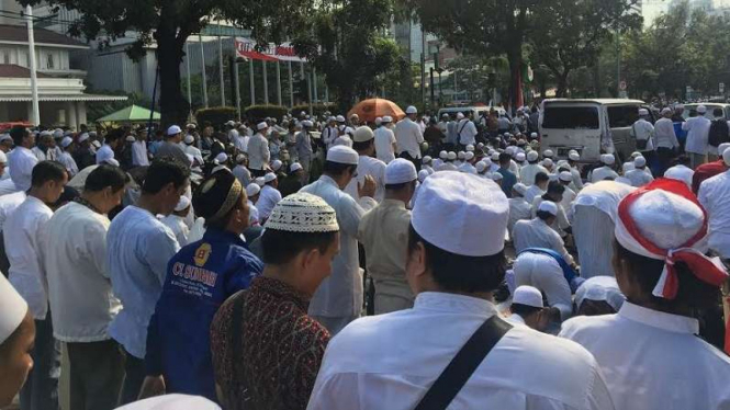 Massa aksi bela Islam salat di depan Balai Kota Jakarta.