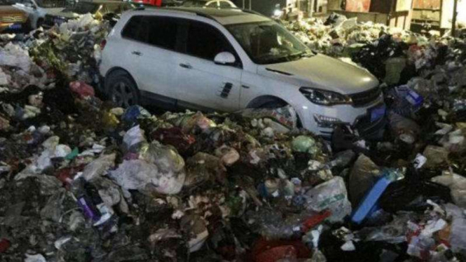 Mobil berada di tumpukan sampah.