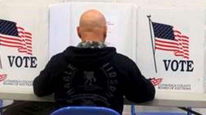 Seorang warga AS sedang memilih di bilik suara.