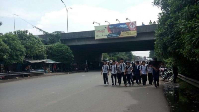 Para pelajar di Tangerang yang berjalan kaki dari sekolah mereka lantaran kendaraan tidak bisa masuk akibat unjuk rasa buruh, Kamis (10/11/2016)