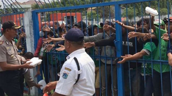 Kapolsek Koja bagikan makanan ke bonek.