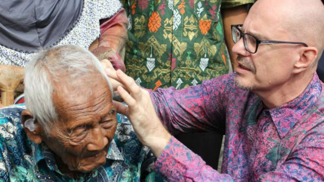Saparman Dimejo alias Mbah Gotho (kiri), warga Sragen yang diklaim sebagai manusia tertua, diperiksa telinganya sebelum dipasangi alat bantu dengar di Solo pada Senin, 14 November 2016.
