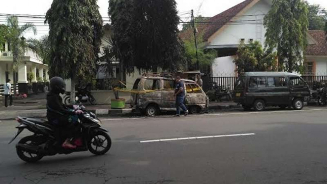 Mobil angkutan umum yang terparkir di depan Polsek Kediri dan Gereja Getsmani di Kota Kediri dibakar orang tak dikenal, Selasa (15/11/2016)